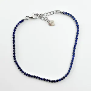 A delicate sterling silver tennis bracelet featuring sparkling blue gemstones.