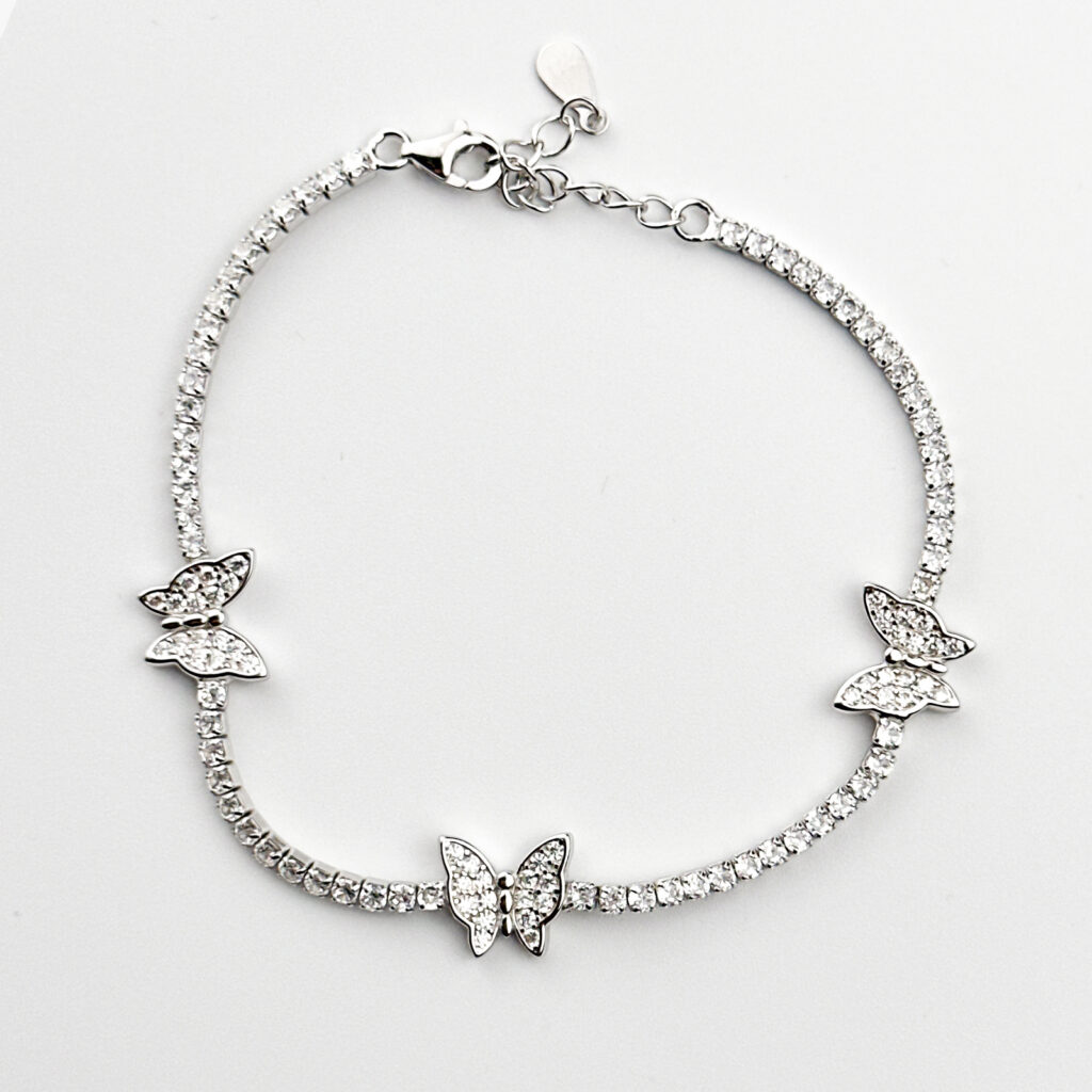 A delicate sterling silver tennis bracelet adorned with three sparkling butterfly charms, each embellished with clear cubic zirconia stones.