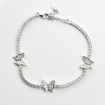 A delicate sterling silver tennis bracelet adorned with three sparkling butterfly charms, each embellished with clear cubic zirconia stones.