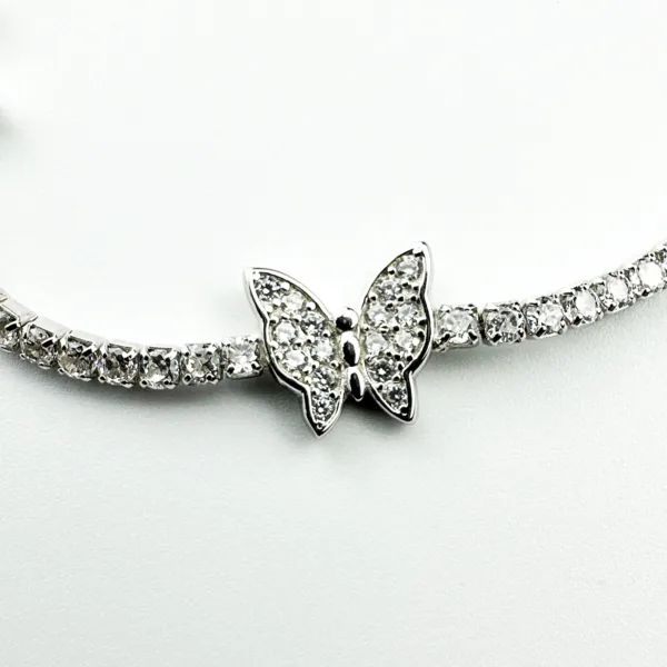 A delicate sterling silver tennis bracelet adorned with sparkling cubic zirconia stones and a butterfly charm embellished with matching stones.