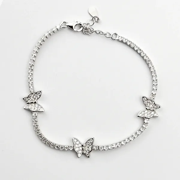 A delicate sterling silver tennis bracelet adorned with three sparkling butterfly charms, each embellished with clear cubic zirconia stones.