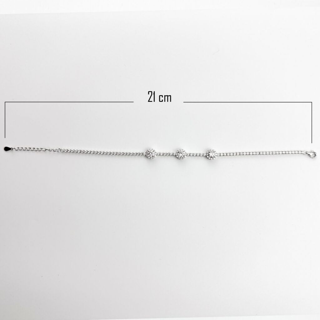 A 21 cm sterling silver tennis bracelet with three clusters of round brilliant-cut clear gemstones.