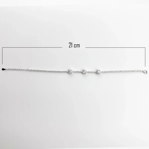 A 21 cm sterling silver tennis bracelet with three clusters of round brilliant-cut clear gemstones.