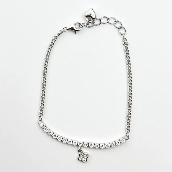 A silver tennis bracelet with cubic zirconia stones and a flower-shaped charm.