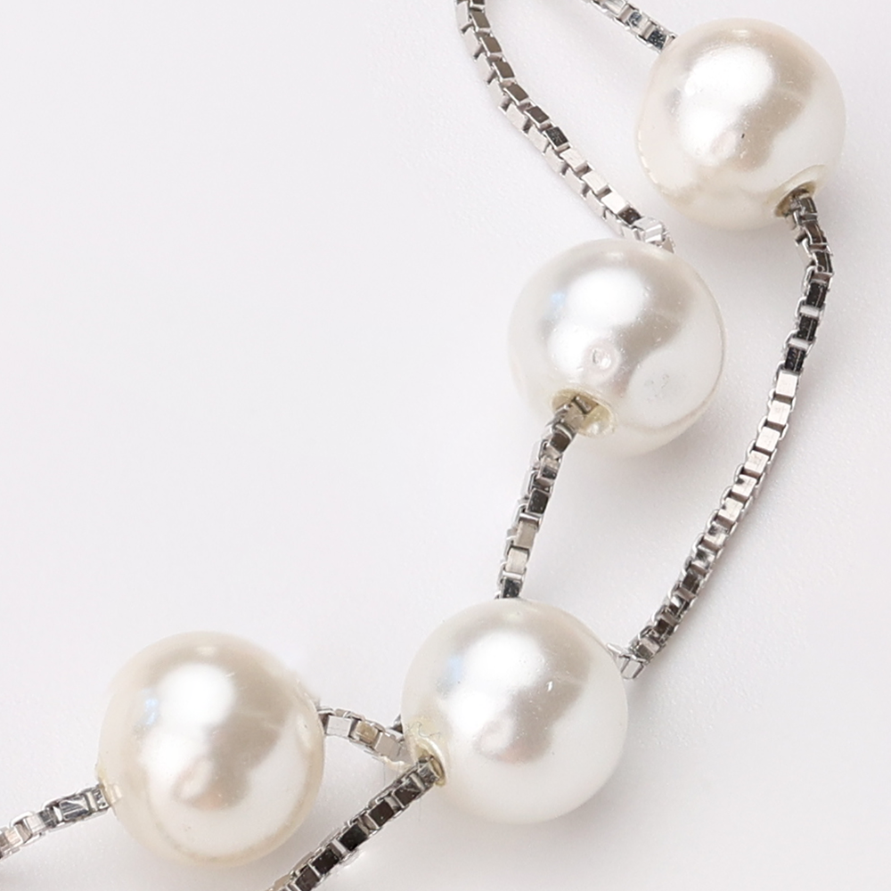 Elegant double-strand bracelet with lustrous white pearls on delicate silver box chain, showcasing intricate craftsmanship