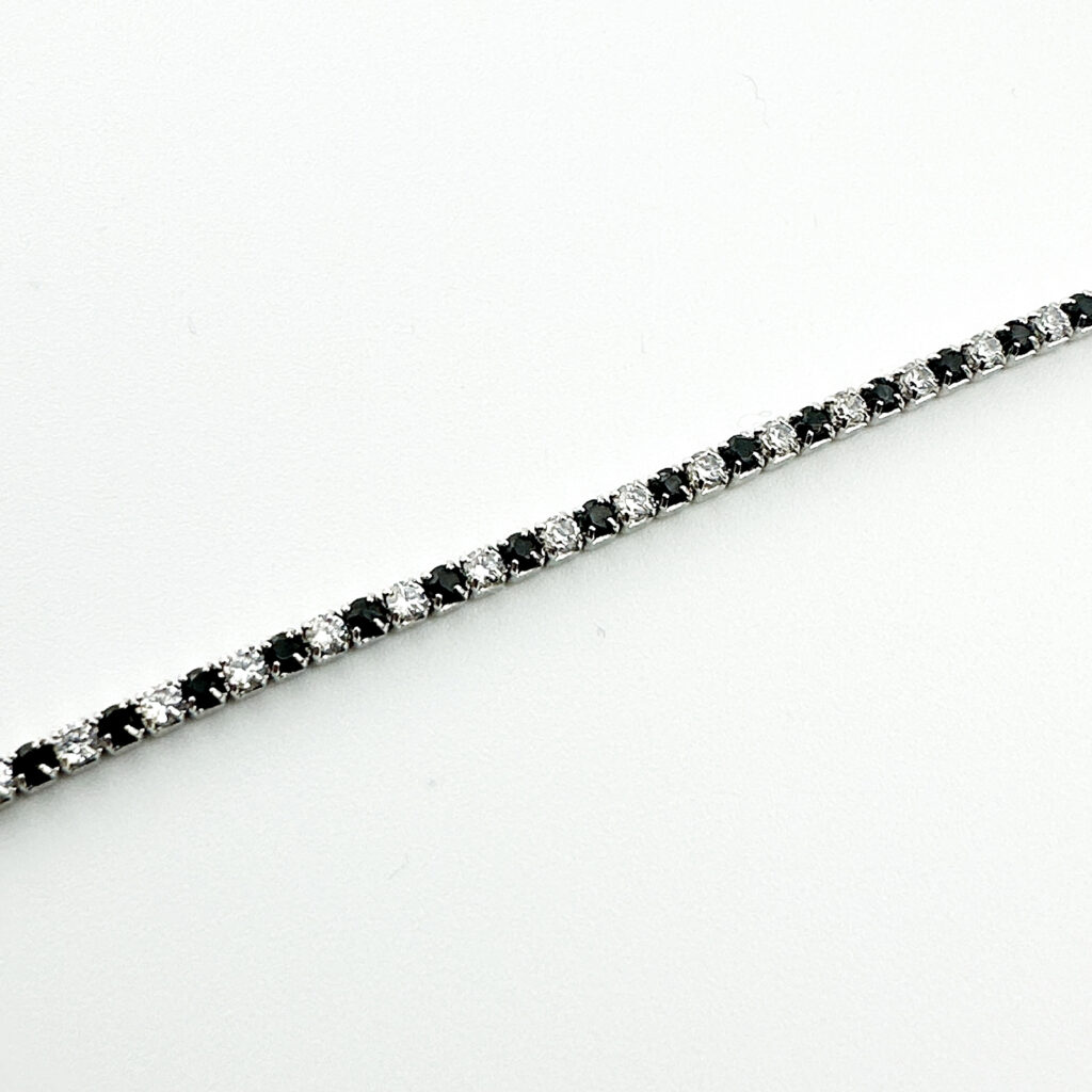 A tennis bracelet with alternating black and white stones