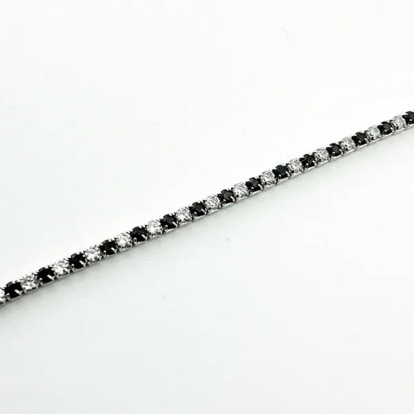 A tennis bracelet with alternating black and white stones