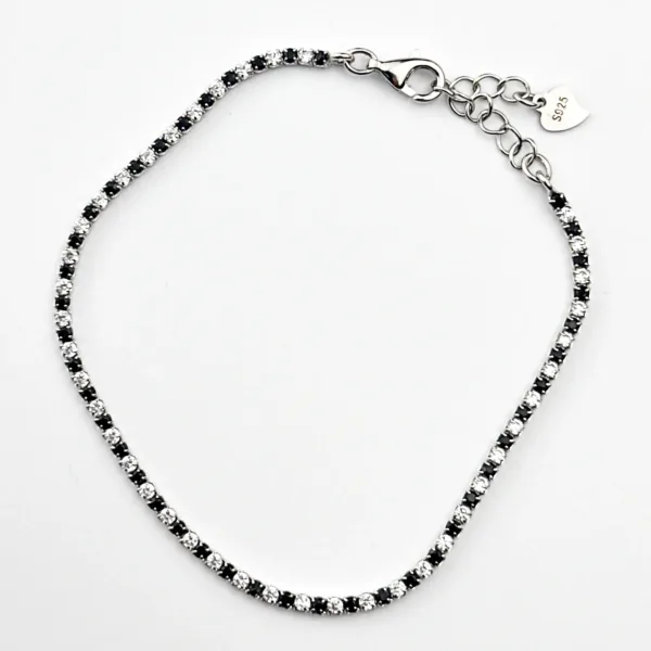 A sterling silver tennis bracelet with alternating black and white cubic zirconia stones.