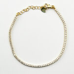 A gold tennis bracelet with small cubic zirconia stones.