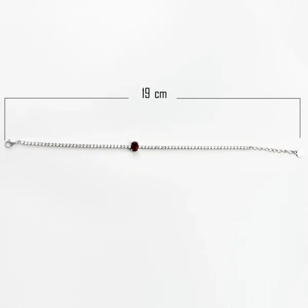 A silver tennis bracelet measuring 19 cm in length, with clear cubic zirconia stones and a red central gemstone.