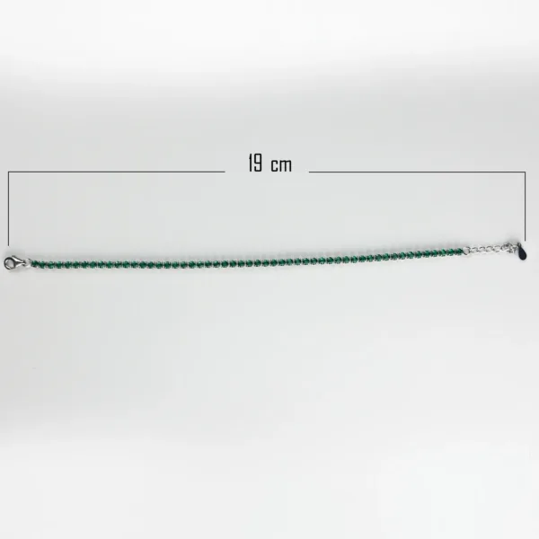 A silver tennis bracelet measuring 19 cm in length, with small square-cut emerald gemstones.