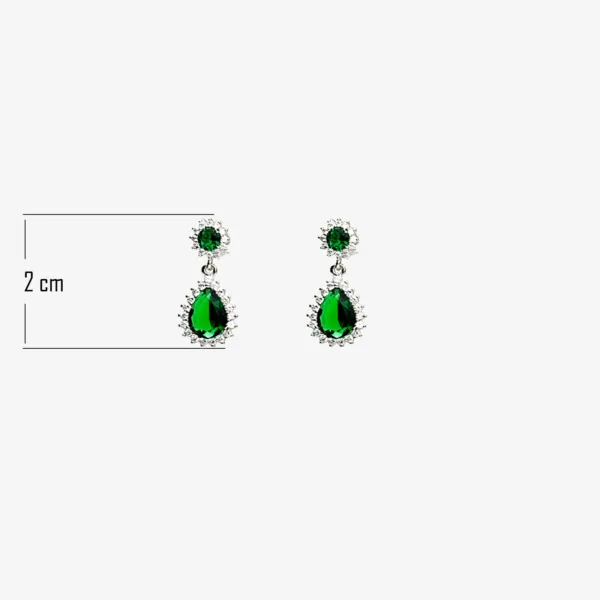 A pair of silver dangle earrings with a teardrop-shaped emerald green gemstone and a smaller round emerald gemstone, both surrounded by a halo of clear gemstones, measuring 2 cm in length.