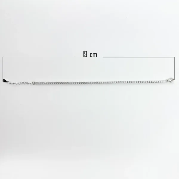 A silver tennis bracelet measuring 19 cm in length, with a clasp closure and small, sparkling stones.