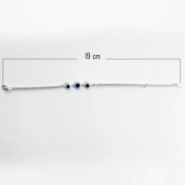 A silver tennis bracelet measuring 19 cm in length, with three blue gemstones surrounded by smaller clear stones.