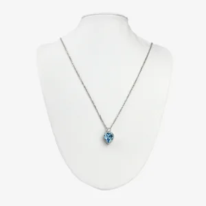 A silver chain necklace with a square-cut blue topaz pendant surrounded by smaller diamonds, displayed on a white mannequin bust.