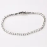 A delicate tennis bracelet featuring a continuous line of sparkling emerald-cut gemstones.