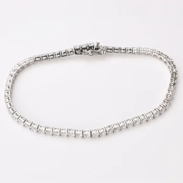 A delicate tennis bracelet featuring a continuous line of sparkling emerald-cut gemstones.