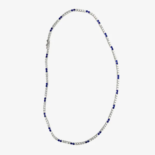 A silver tennis necklace with alternating small, round, clear gemstones and blue sapphires.