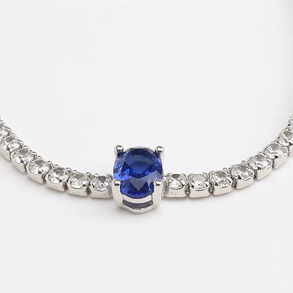 Elegant silver tennis bracelet with oval blue sapphire centerpiece and cubic zirconia accents