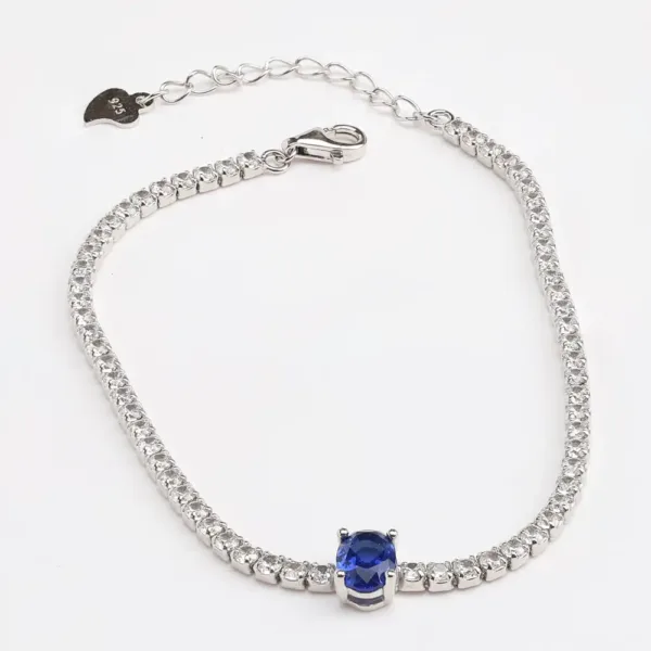 Elegant silver tennis bracelet with blue sapphire centerpiece and cubic zirconia accents