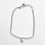 Sterling silver bracelet with cubic zirconia and four-leaf clover charm, top view