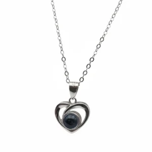 Sterling silver heart pendant with black stone on delicate chain, front view